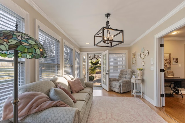 living room featuring crown molding, light hardwood / wood-style flooring, and a notable chandelier