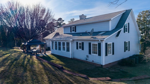 rear view of property featuring a gazebo and a lawn