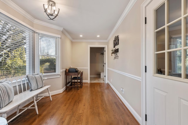 corridor with crown molding, hardwood / wood-style floors, and a notable chandelier