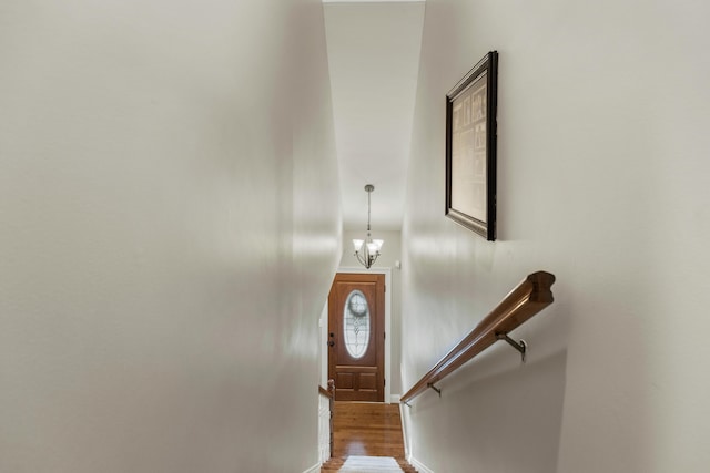 stairway featuring hardwood / wood-style flooring and a chandelier