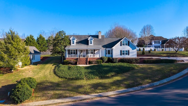 cape cod-style house with a front yard and covered porch