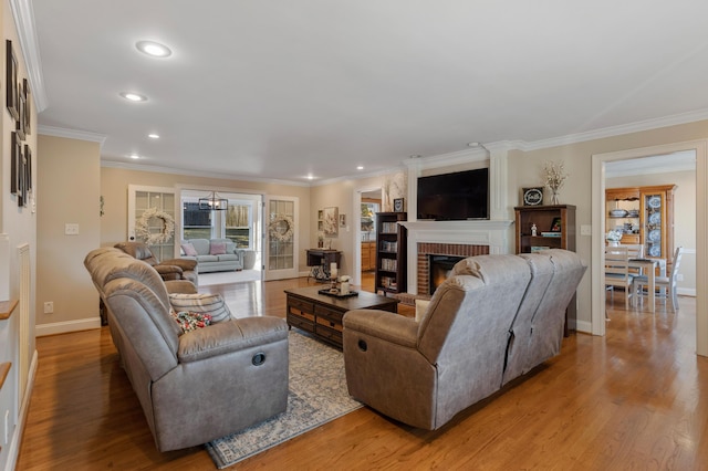 living room featuring a brick fireplace, light hardwood / wood-style flooring, and ornamental molding