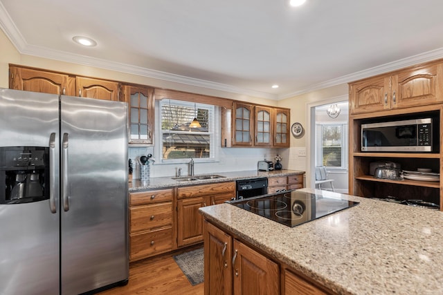 kitchen with light wood-type flooring, crown molding, sink, and black appliances