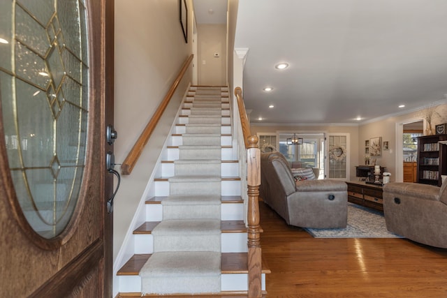 staircase featuring hardwood / wood-style flooring and crown molding