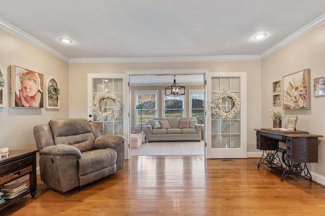 sitting room featuring ornamental molding, a chandelier, and light hardwood / wood-style flooring