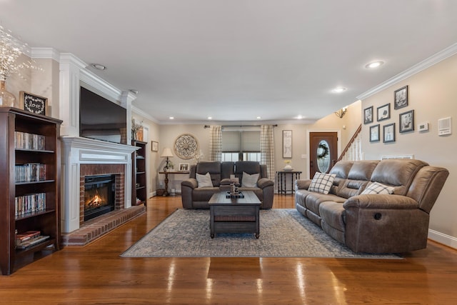 living room featuring ornamental molding, a brick fireplace, and hardwood / wood-style floors