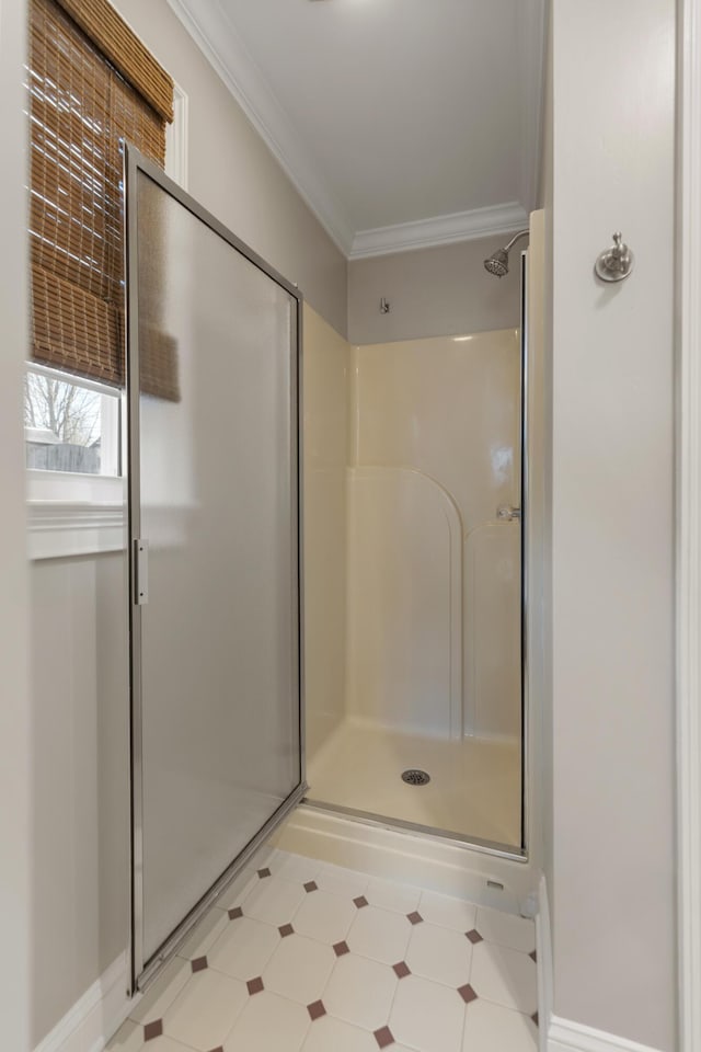 bathroom featuring ornamental molding and a shower with door