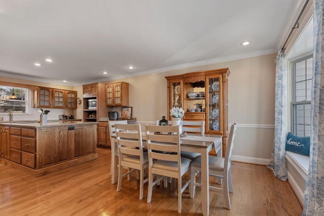 dining area with crown molding and light hardwood / wood-style flooring