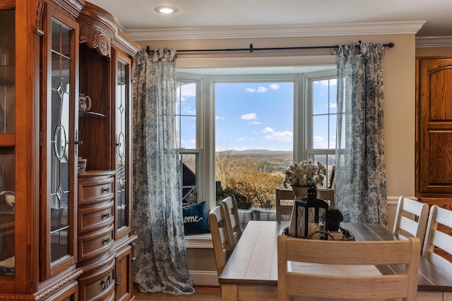 dining space with hardwood / wood-style floors and crown molding