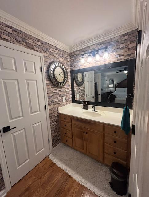 bathroom with ornamental molding, wood finished floors, and vanity