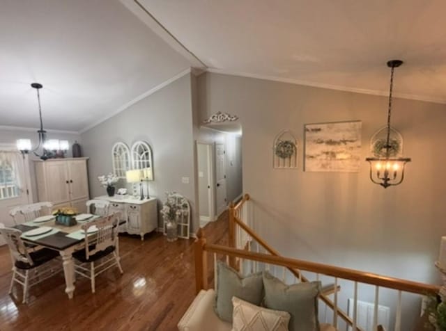 dining space with ornamental molding, baseboards, dark wood finished floors, a notable chandelier, and vaulted ceiling