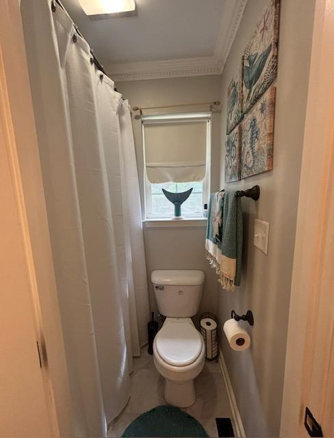 full bathroom featuring crown molding, toilet, a shower with shower curtain, and tile patterned flooring