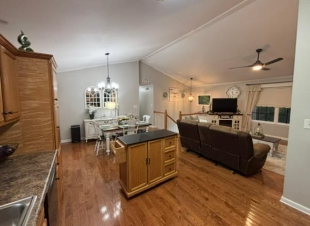 kitchen featuring dark countertops, baseboards, ceiling fan with notable chandelier, and wood finished floors