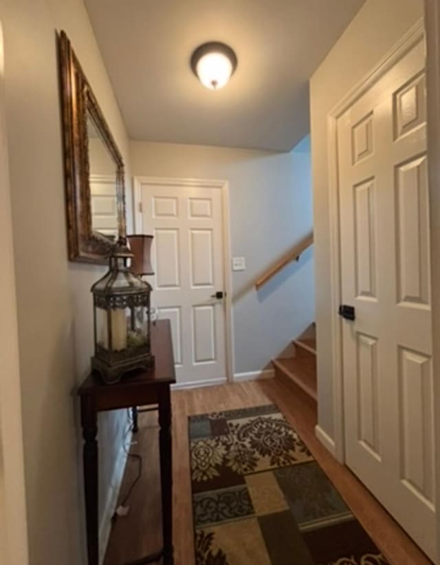 entryway featuring stairway, baseboards, and wood finished floors