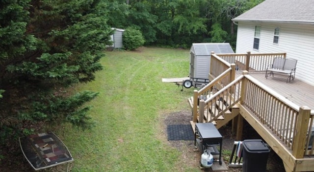 view of yard with a storage shed, a deck, an outbuilding, and stairs