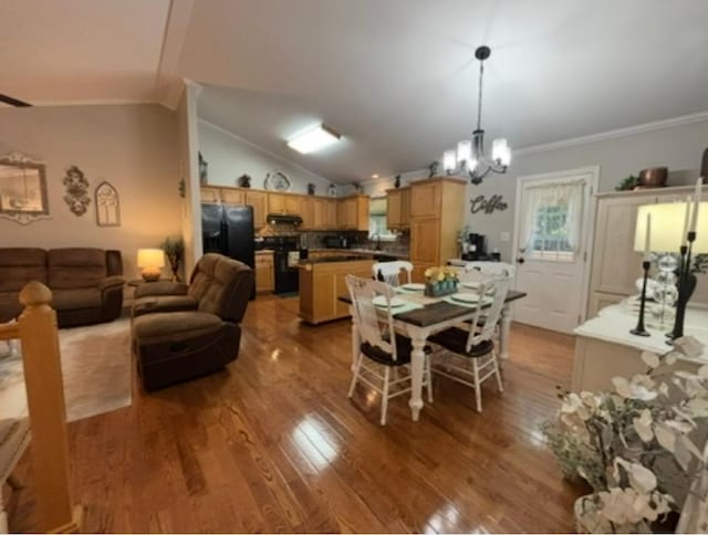dining room featuring crown molding, an inviting chandelier, vaulted ceiling, and wood finished floors