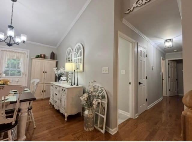 dining area with baseboards, a notable chandelier, ornamental molding, and wood finished floors