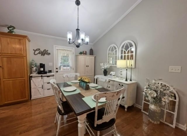 dining space featuring crown molding, wood finished floors, baseboards, lofted ceiling, and an inviting chandelier