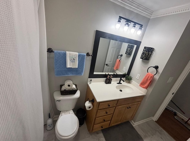 bathroom featuring vanity, ornamental molding, baseboards, and toilet