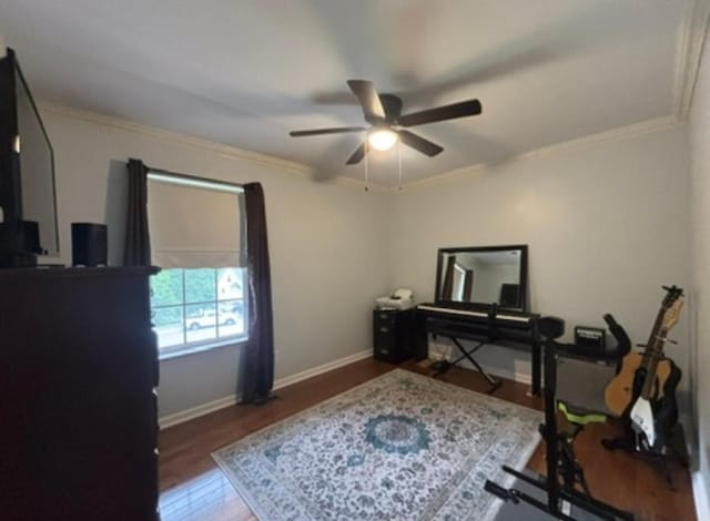 home office featuring baseboards, ornamental molding, a ceiling fan, and wood finished floors