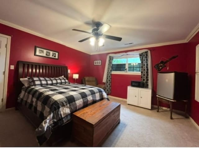 carpeted bedroom featuring crown molding, a ceiling fan, baseboards, and visible vents
