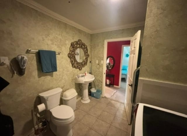 bathroom with tile patterned flooring, ornamental molding, and toilet