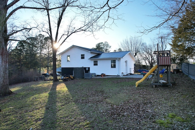 back of property with metal roof and a playground