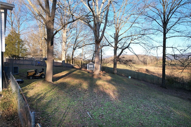 view of yard featuring a storage shed, an outbuilding, and a fenced backyard