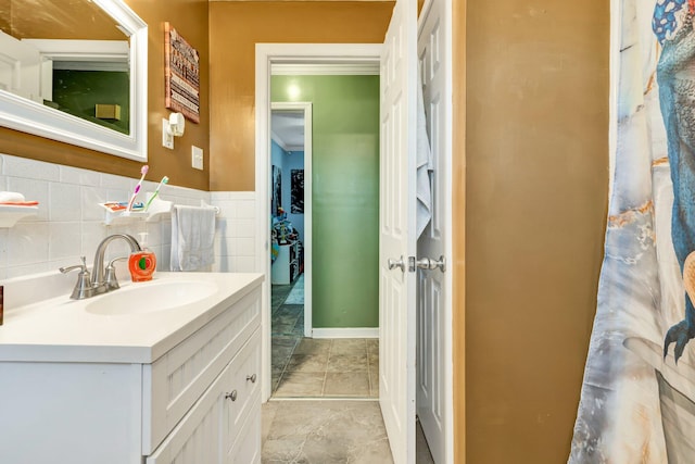 bathroom with wainscoting, tile walls, and vanity