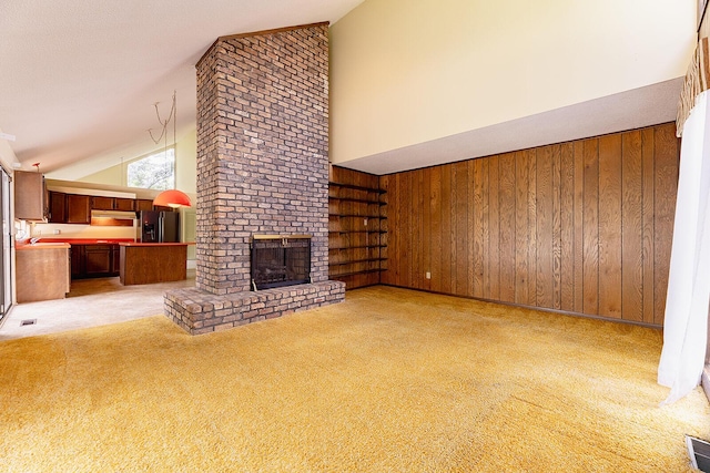 604 Augusta National Way, Knoxville, TN 37934 - unfurnished living room featuring light colored carpet, a fireplace, high vaulted ceiling, and wood walls