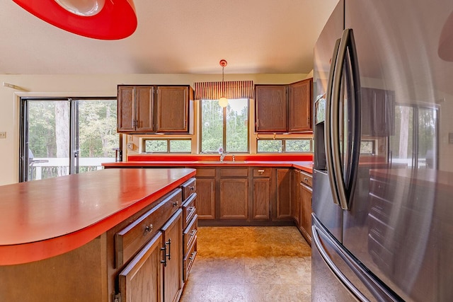 604 Augusta National Way, Knoxville, TN 37934 - kitchen with stainless steel fridge, brown cabinetry, and hanging light fixtures