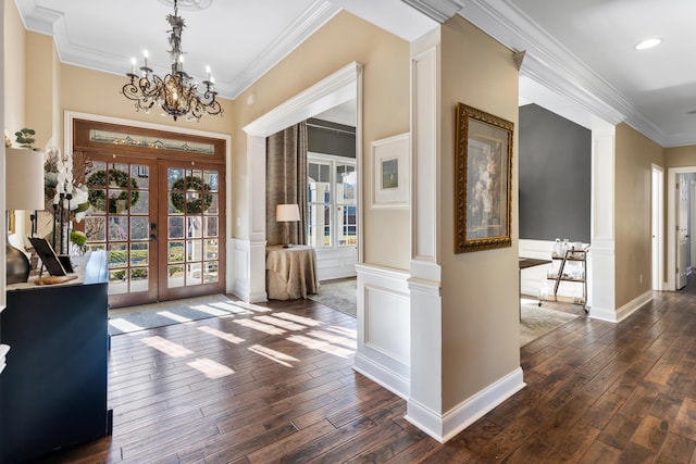 entrance foyer with french doors, ornamental molding, dark hardwood / wood-style floors, and a notable chandelier