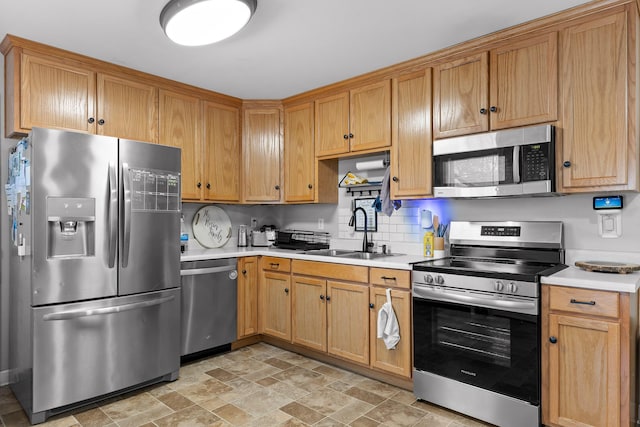 kitchen with appliances with stainless steel finishes, sink, and backsplash