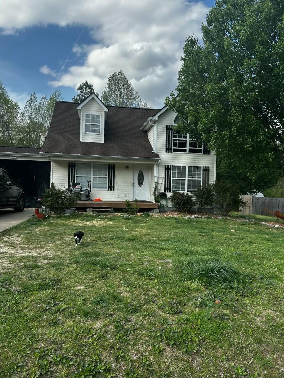 view of front facade with fence, a garage, a front lawn, roof with shingles, and a porch