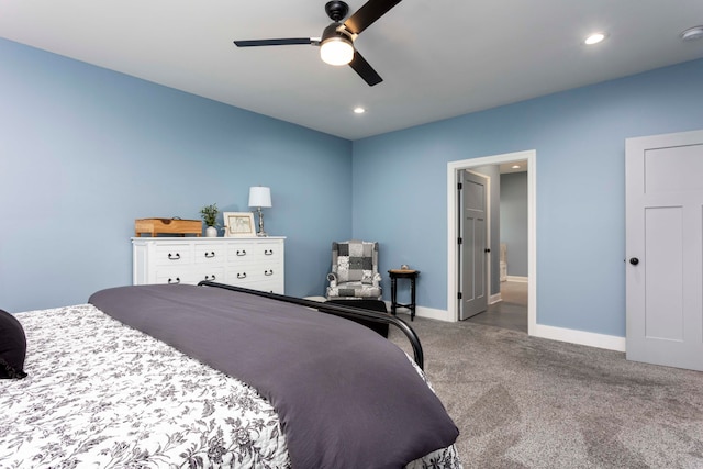 carpeted bedroom with ensuite bath and ceiling fan