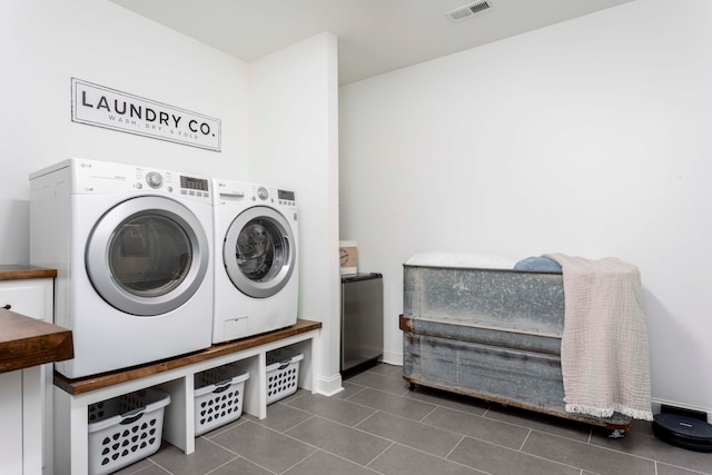 washroom with dark tile patterned flooring and washing machine and dryer