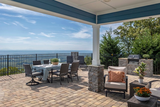 view of patio / terrace with area for grilling, a water view, and grilling area