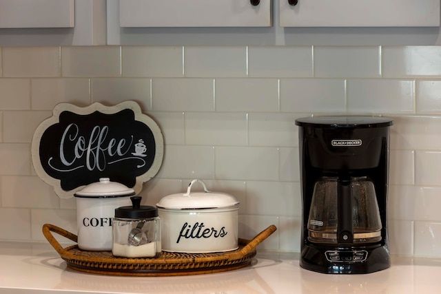 details featuring decorative backsplash and white cabinetry