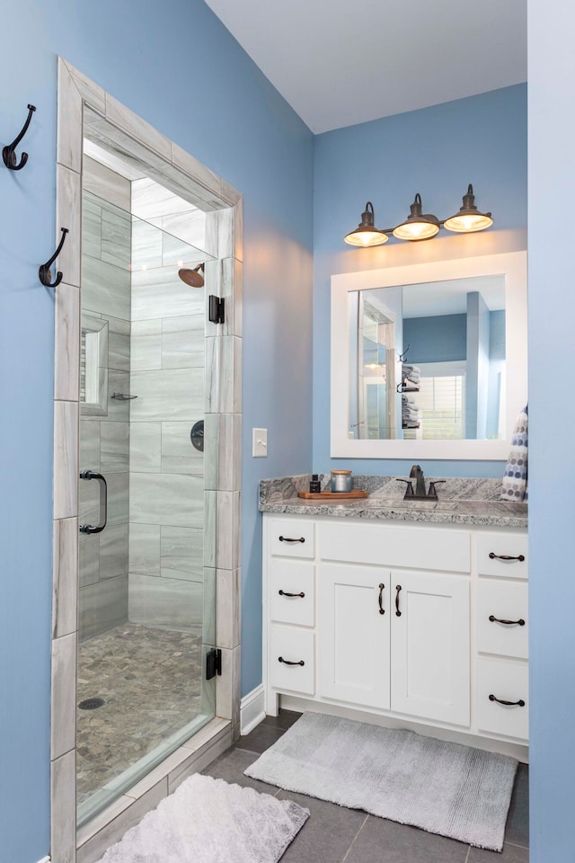 bathroom featuring tile patterned floors, vanity, and a shower with door