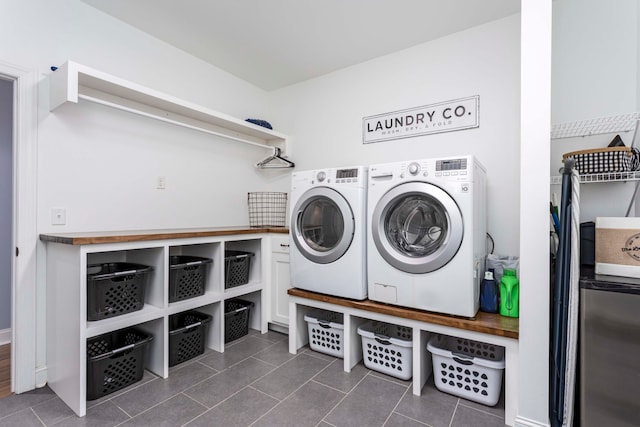 laundry room with dark tile patterned flooring and separate washer and dryer