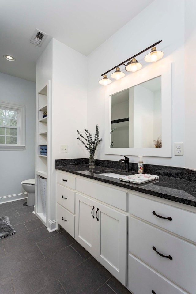 bathroom featuring tile patterned floors, vanity, and toilet