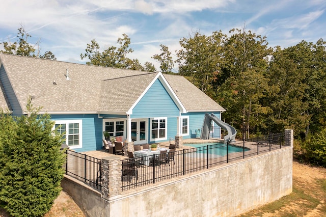 back of property with a fenced in pool, an outdoor living space, and a patio