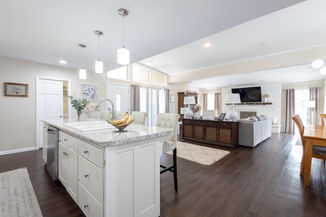 kitchen featuring sink, dishwasher, a wealth of natural light, white cabinets, and a center island with sink