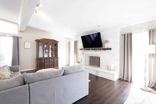 living room featuring beam ceiling, a stone fireplace, and dark hardwood / wood-style floors