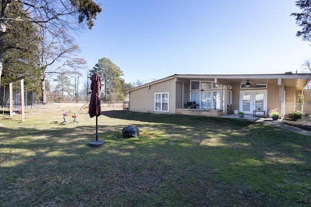 view of yard featuring french doors, ceiling fan, and a trampoline