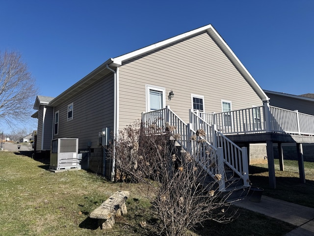 view of side of home featuring a deck and a yard