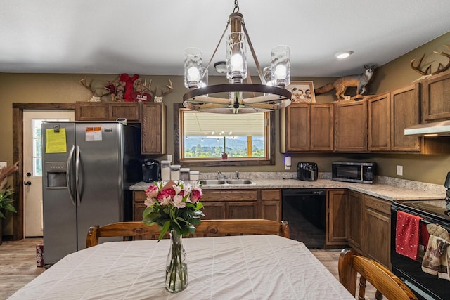 250 Creek Rd, Sweetwater, TN 37874 - kitchen with black appliances, a chandelier, a sink, under cabinet range hood, and light wood-style flooring