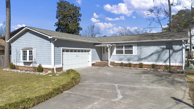 ranch-style house featuring driveway, an attached garage, and a front yard