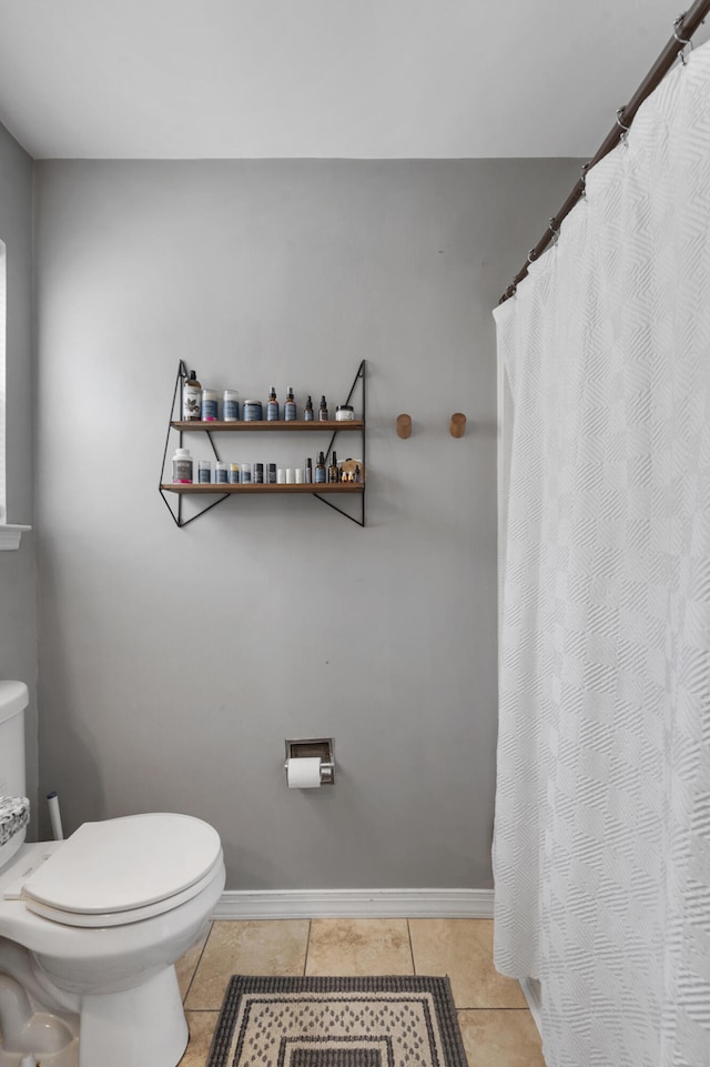 bathroom with toilet, tile patterned flooring, and baseboards