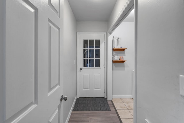 doorway with light wood-style flooring and baseboards